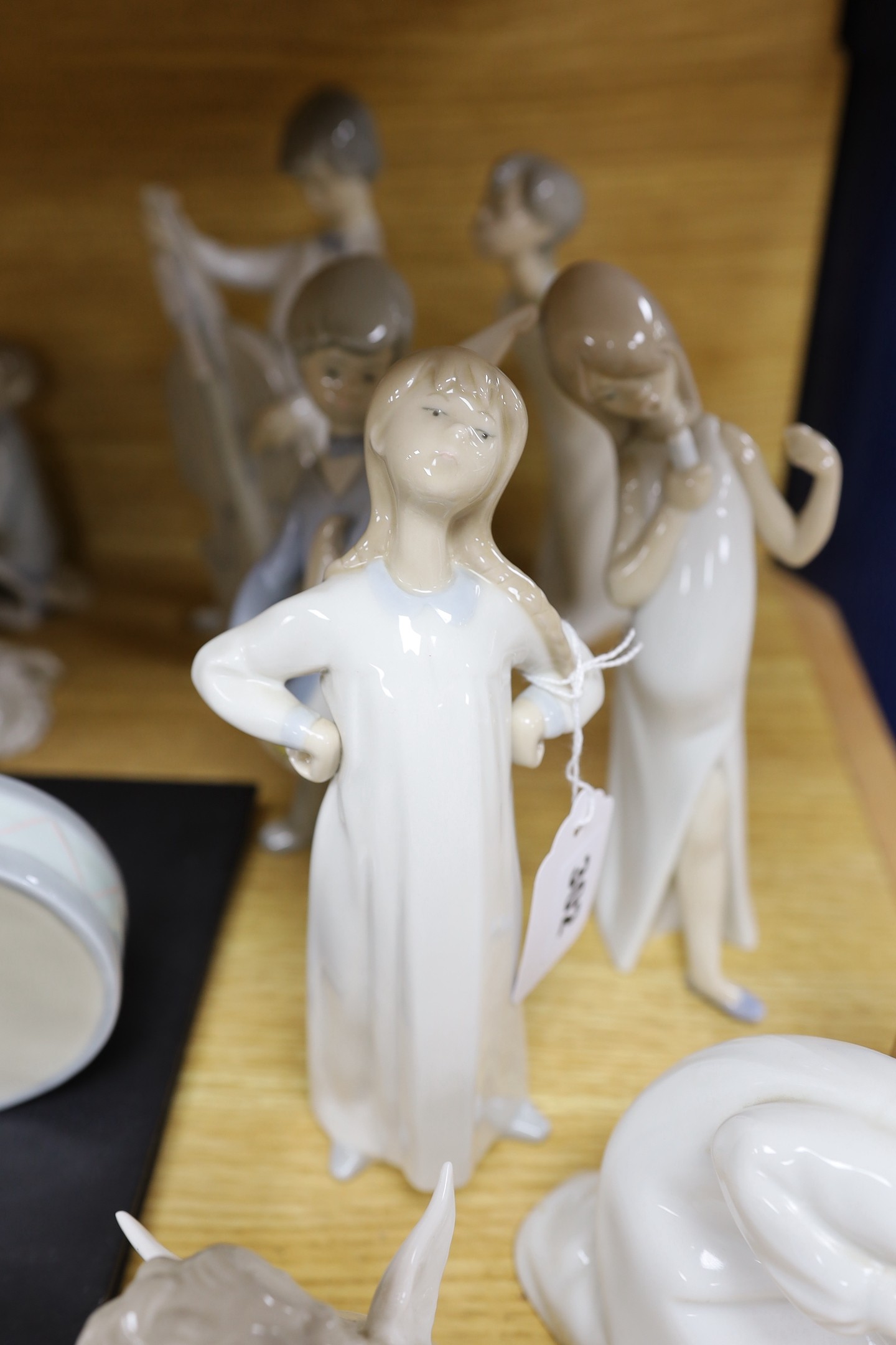 A Lladro collection: seven figures, five further damaged figures and a Lladro reference book